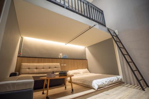 an attic bedroom with a bed and a couch at Chief Homestay輕旅套房附設電梯#本國旅客須先匯款 in Tainan