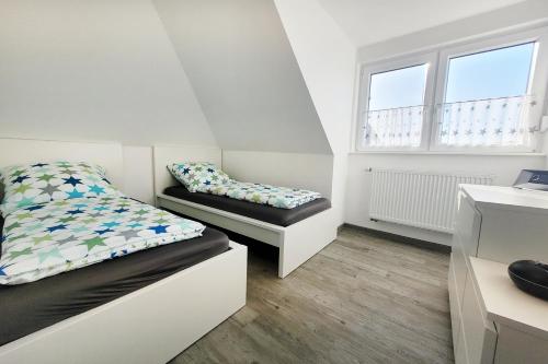 a bedroom with two beds and two windows at Dieken's Huus in Wangerland