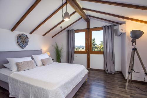 a bedroom with a white bed and a window at Villa Kora in Kallithea Rhodes