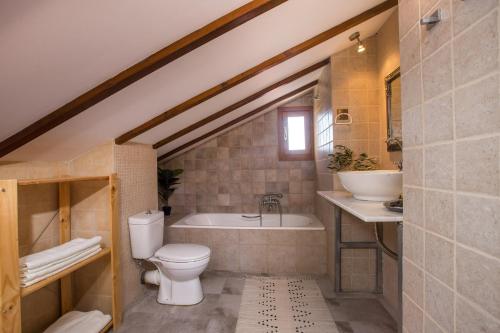 a bathroom with a toilet and a tub and a sink at Villa Kora in Kallithea Rhodes