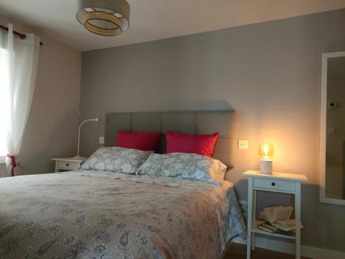 a bedroom with a large bed with red pillows at La Antigua Muralla in Burgos