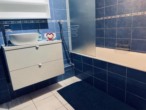 La salle de bains est pourvue d'un lavabo et de carrelage bleu. dans l'établissement STUDIO VAISE 1 DANS 69009 LYON, à Lyon
