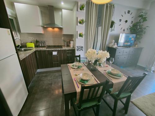 una cucina con tavolo in legno con sedie e una sala da pranzo di Casa Bella Apartment BY NAMASTE ELITE a Torremolinos