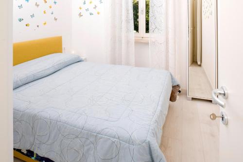 a bedroom with a bed with a blue blanket and a window at DALIAHOUSE Bardolino family and cozy apartment in Bardolino