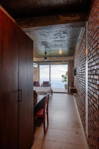 a dining room with a table and a brick wall at Vantage hills Haputale in Haputale
