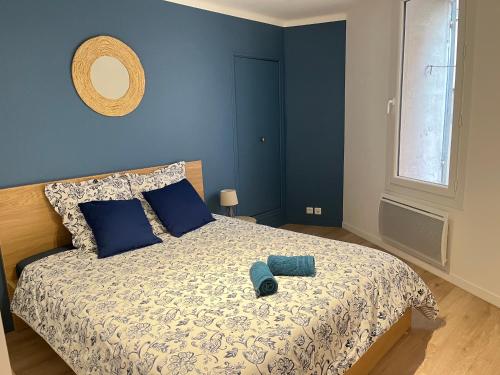 een slaapkamer met een bed met een blauwe muur bij L'Aristide in Aix-en-Provence