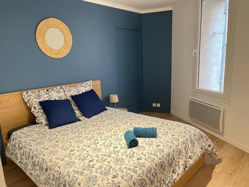 une chambre avec un lit avec un mur bleu dans l'établissement L'Aristide, à Aix-en-Provence