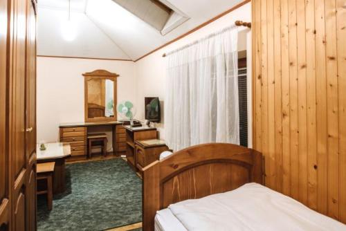 a bedroom with a bed and a desk and a mirror at Gostisce Ulipi in Slovenske Konjice