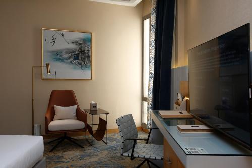 a hotel room with a desk and a bed and a chair at Grand Plaza Hotel - Jazan in Jazan