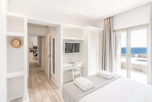 a white bedroom with a view of the ocean at Ethereal Villa Mykonos in Kalafatis