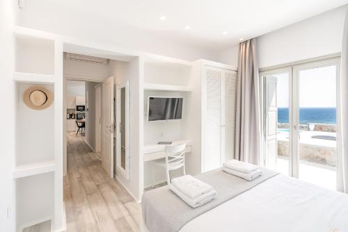 カラファティスにあるEthereal Villa Mykonosの白いベッドルーム1室(海の景色を望む)