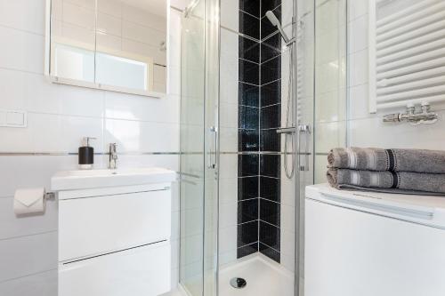 ein Bad mit einer Glasdusche und einem Waschbecken in der Unterkunft Apartament Clara na klifie in Rewal