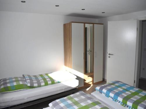 2 camas en una habitación con espejo en Ferienhaus Anni en Leipheim