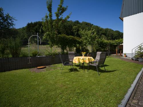 a table and chairs sitting in a yard with a table and chairs at JUNIPRO Apartments Haustadt in Beckingen