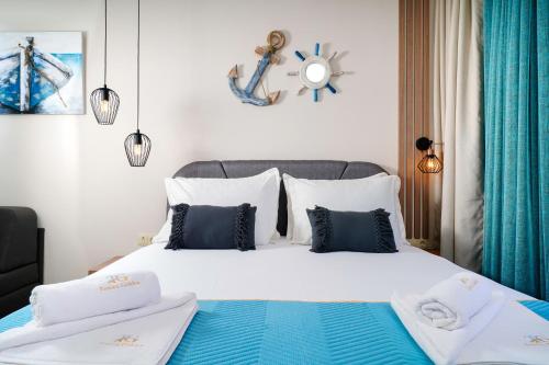 a bedroom with a bed with blue and white pillows at Tereza Golden in Chrysi Ammoudia