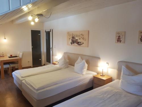 a bedroom with two beds and a table and two lamps at La Locanda Ristorante Pizzeria Garni in Ohlstadt