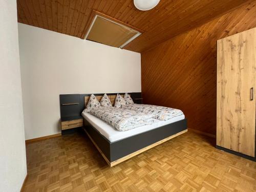 1 dormitorio con 1 cama con techo de madera en Ferienwohnung Dorfzentrum en Disentis