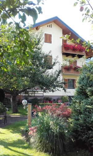 a building with a flower garden in front of it at Family- Home Alpenblick in Dellach im Drautal