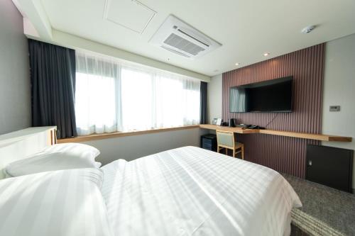 a hotel room with a bed and a television at Seoul Olympic Parktel in Seoul