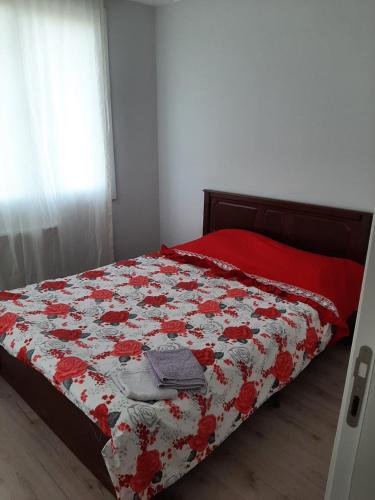 a bedroom with a bed with a red and white quilt at 2+1 RESIDENCE STADYUM in Sarıhamzalı