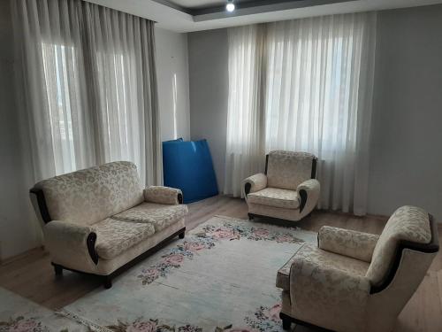 uma sala de estar com duas cadeiras e um sofá em 2+1 RESIDENCE STADYUM em Sarıhamzalı