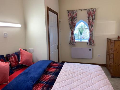 Un dormitorio con una cama grande y una ventana en Cut Limestone Apartment Riverside Lodge, en Carlow
