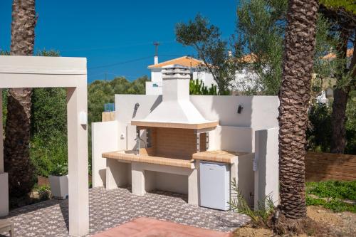 a white house with a stove in a yard at Villa Carvella - A Sublimely Relaxing Escape! in Tsilivi