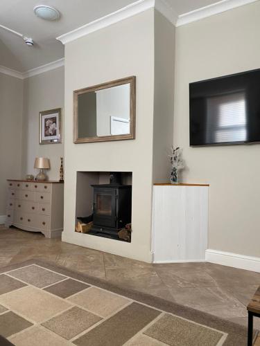 a living room with a fireplace and a television at Westdene in Skegness