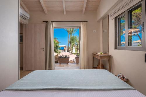 sypialnia z łóżkiem i dużym oknem w obiekcie Villa Carvella - A Sublimely Relaxing Escape! w mieście Tsilivi