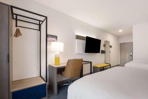 a hotel room with a bed and a desk and a tv at Comfort Inn & Suites Gaylord in Gaylord