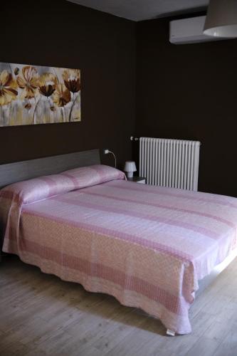 um quarto com uma cama com um cobertor rosa em Sapigno B&B em SantʼAgata Feltria