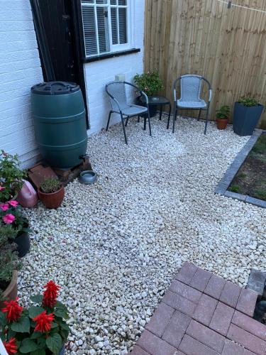 a patio with two chairs and a barrel and flowers at Westdene in Skegness