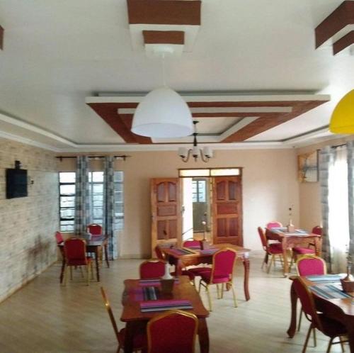 a restaurant with tables and chairs in a room at Villa Serene Hotel in Kitale