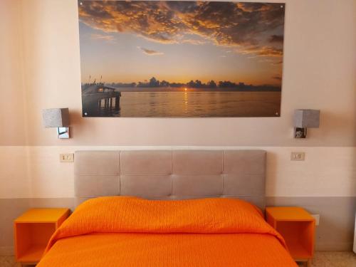 a bedroom with a bed and a painting on the wall at La locanda di Gioele in Lido di Camaiore