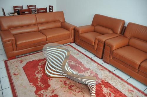 a living room with two leather couches and a table at Superbe Studio dans un immeuble de haut standing in Douala