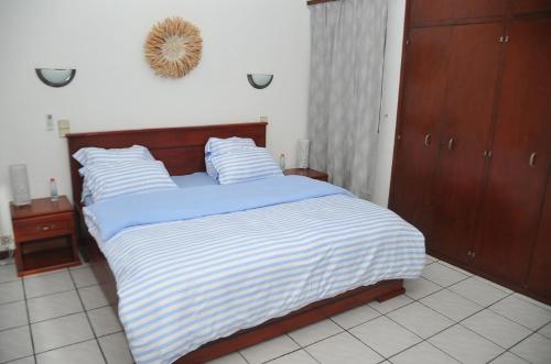 a bedroom with a bed with blue and white stripes at Superbe Studio dans un immeuble de haut standing in Douala