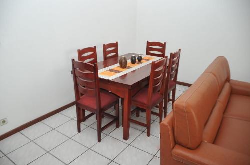 a dining room with a table and chairs and a couch at Superbe Studio dans un immeuble de haut standing in Douala