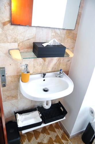 a bathroom with a white sink and a mirror at Superbe Studio dans un immeuble de haut standing in Douala