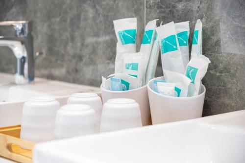a group of toothbrushes in cups on a counter at 隱山行旅包棟民宿 in Puli