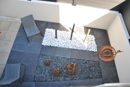 - une vue sur le jardin avec des rochers et des bancs dans l'établissement Cap sur le Sable à Moguériec, à Sibiril