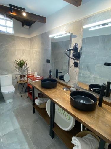 a bathroom with two sinks and a mirror at Apartamentos Rurales Calleabajo - 3 Estrellas in Hervás