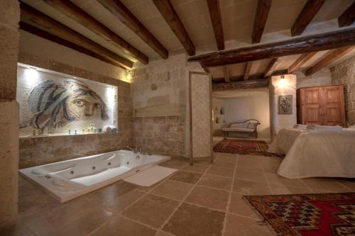 a large bathroom with a bath tub in a room at Sinasos Palace Cave Hotel in Urgup