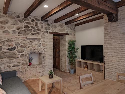 a living room with a stone wall and a television at Casa Bruna in Cobisa
