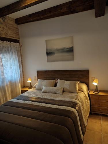 a bedroom with a large bed with two lamps at Casa Bruna in Cobisa