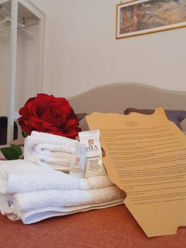 a pile of towels and a rose on a bed at Wine Suite in Torricella