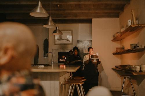 a group of people standing in a kitchen at Qambathi Mountain Lodge in Kamberg Valley