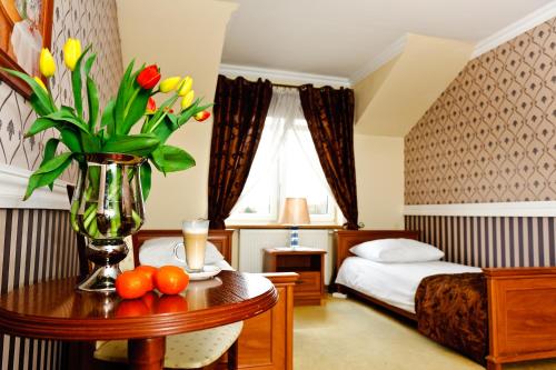 a hotel room with a vase of flowers on a table at Hotel Pałac Akropol in Lublin