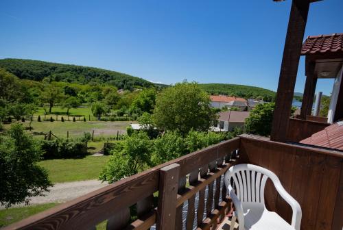 a white bench sitting on a balcony overlooking a field at Alabástrom Panzió és Étterem in Bogács