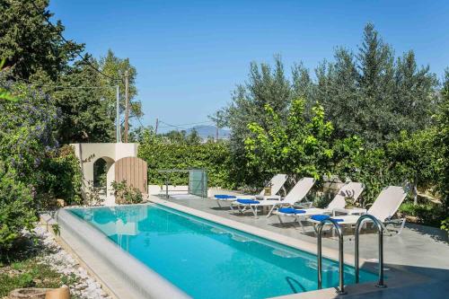 una piscina con tumbonas, una mesa y una piscina en Fanari House, en Argostoli