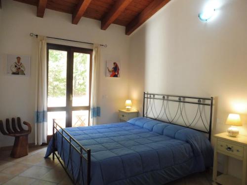 ein Schlafzimmer mit einem blauen Bett und einem Fenster in der Unterkunft Mi casa el mar! Grazioso attico 400 mt alla spiaggia e al centro in Castelsardo